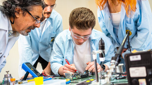 Gruppe junger Menschen in technischer Berufsausbildung mit Lehrer. Gruppe junger Menschen in technischer Berufsausbildung mit Lehrer.