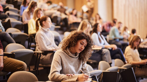 Studenten im Hörsaal einer Universität schreiben eine Klausur. Studenten im Hörsaal einer Universität schreiben eine Klausur.